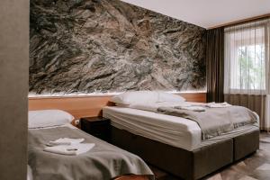尼赖吉哈佐Park Hotel Sóstó的酒店客房,配有两张带毛巾的床