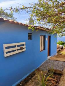 费尔南多 - 迪诺罗尼亚Casa Beco do Céu的蓝色的房子,设有窗户和栅栏