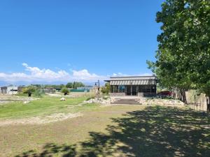 图蓬加托火山Entrevides, Tupungato, Valle de uco的田野上的建筑,有树