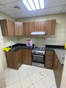 阿吉曼Holiday Home Master bed room in Ajman city UAE的厨房配有木制橱柜和炉灶。