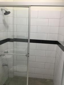 安东尼奥港MisBHaven Resort and Spa的玻璃淋浴间,铺有黑白瓷砖