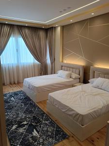 开罗شقة ألترا لوكس بالمهندسين的一间卧室设有两张床和大窗户
