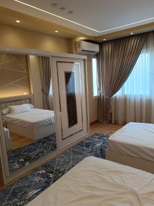 开罗شقة ألترا لوكس بالمهندسين的酒店客房,设有两张床和镜子