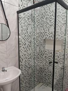 特拉曼达伊Pousada Luz Beira mar的一间带玻璃淋浴和水槽的浴室