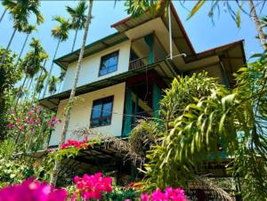 PanamaramGreens Vista Wayanad - Premium Homestay Near Natural Stream的花园中种满鲜花的房子