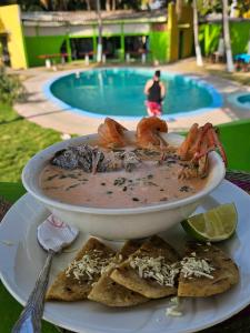 拉利伯塔德hostal y Restaurante Entre Olas的池边一盘带虾和玉米片的食物