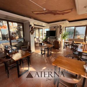 迪基利ATERNA HOTEL的餐厅设有木桌、椅子和窗户。