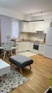 斯科普里Katja’s Apartment in Hellga River Residence的厨房配有白色橱柜和桌椅