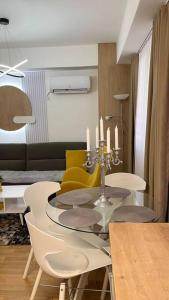 斯科普里Katja’s Apartment in Hellga River Residence的一间设有玻璃桌和黄色椅子的用餐室
