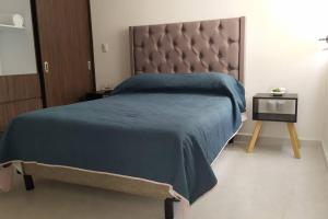 莫雷利亚Dpto en Altozano 34的一间卧室配有一张带蓝色毯子和一张桌子的床。