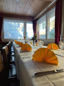 施特歇尔贝格Hotel-Restaurant Stechelberg Bed & Breakfast的一张长桌,上面有橙色伞