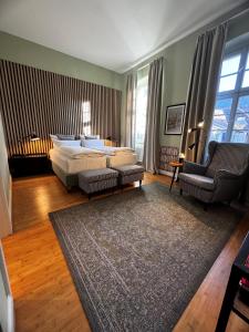 海德堡阿尔滕布吕克酒店的一间卧室配有一张床、一张沙发和一把椅子