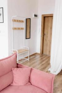 克维曾Apartament Pastelowy Kwidzyn的客厅配有粉红色的沙发和桌子