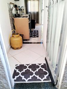 萨夸雷马Mini Casa Aconchegante的走廊上设有厨房,地板上铺着地毯