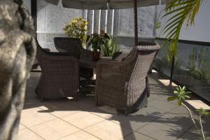 萨尔瓦多矮牵牛之家精品旅馆的庭院里设有四把藤椅和一张桌子