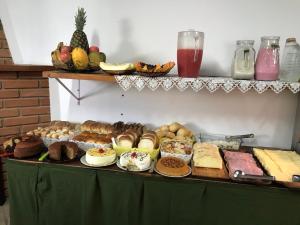 坎波斯杜若尔当Pousada Recanto da Giovana的一张桌子,上面摆放着各种面包和糕点