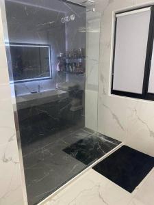 迈松阿尔福Maison 160m2 à 15 min de PARIS/accord arena bercy的一间带玻璃淋浴间和水槽的浴室