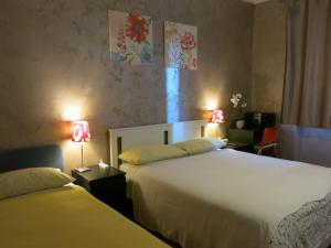 格鲁利亚斯科Thany casa的酒店客房设有两张床和两盏灯。
