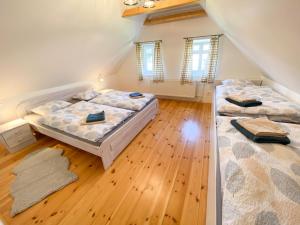 斯姆尔克山麓新城Chalupa Ludvíkov的客房内设有两张床,铺有木地板,设有窗户。