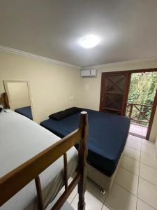 马利西亚斯B12 Casa em Maresias condomínio a 50 metros da praia的一间卧室设有两张双层床和一扇窗户。