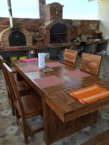 里奥阿托MM NAPA VILLAGE的一张带椅子的木桌和比萨饼烤箱