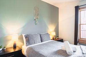 蒙特朗布朗La petite saisonnière的一间卧室配有一张床、两盏灯和一个窗户。