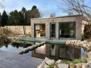 斯姆尔克山麓新城Chalupa Ludvíkov的水中的小房子,有游泳池