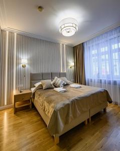 下乌斯奇基尼夫别墅酒店的一间卧室设有一张大床和一个大窗户