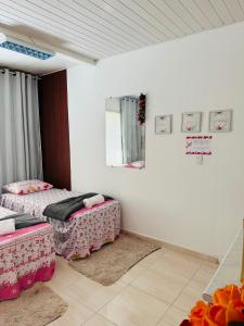 贝伦Hostel das Flores的配有2张床的白色墙壁和镜子