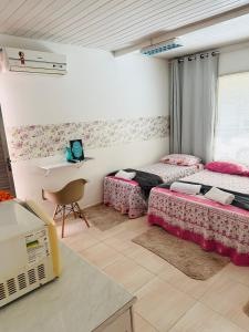 贝伦Hostel das Flores的客房设有两张床和一张带笔记本电脑的桌子。