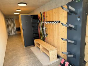 布鲁尼科Luis Chalet的一间房间,墙上有滑雪板,还有长凳