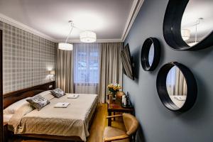 下乌斯奇基尼夫别墅酒店的卧室配有一张床,墙上设有镜子