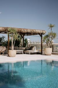 贝莱斯Villa Soluna的度假村的游泳池,设有凉亭和棕榈树