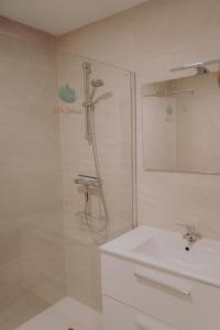 贝莱斯Villa Soluna的带淋浴和盥洗盆的白色浴室