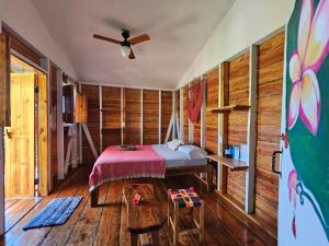 小玉米岛Lighthouse Hotel and Spa, Little Corn island, Nicaragua的卧室配有一张床铺,位于带木墙的房间内