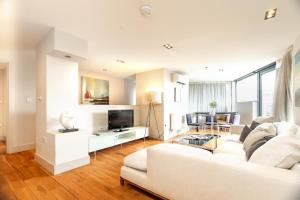 伦敦Modern City Apartments的客厅配有白色沙发和电视
