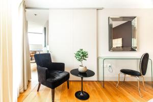 伦敦Modern City Apartments的客厅配有两把椅子、一张桌子和镜子