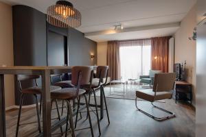 玛库姆Zuiderzeestate 35, prachtig appartement aan het IJsselmeer的一间客厅,客厅里设有酒吧和椅子