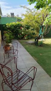 蒙得维的亚Casa Independiente en Punta Gorda的两把长椅坐在花园旁的路边