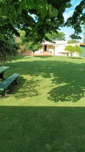 蒙得维的亚Casa Independiente en Punta Gorda的草地上设有绿长椅的公园