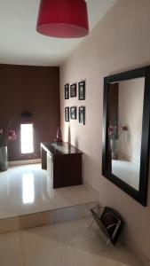 特尔马斯德里奥翁多Infinit Home Duplex entero的客厅配有镜子和桌子