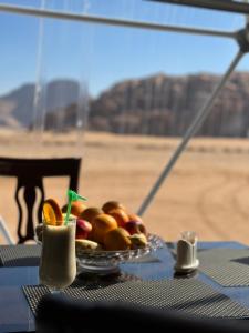 瓦迪拉姆Wadi rum anwar luxury camp的一张桌子上的水果盘,享有沙漠的景色