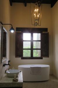 卡德雷塔Hacienda Tovares的带浴缸、水槽和窗户的浴室