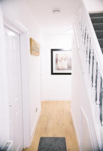 锡德卡普6 bedroom property的一条带白色墙壁的走廊和铺有地毯的楼梯