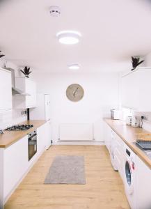 锡德卡普6 bedroom property的厨房铺有木地板,配有白色橱柜。