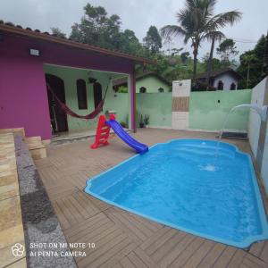马卡埃Casa Muro Alto-Sana Rj的一个带滑梯的游泳池和一个游乐场
