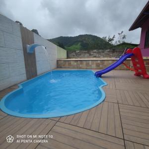 马卡埃Casa Muro Alto-Sana Rj的甲板上设有喷泉的游泳池