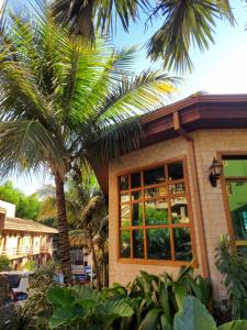 里贝朗普雷托Hotel Pousada Santa Rita的前面有棕榈树的房子