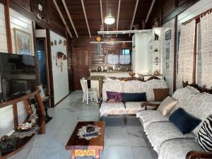 弗洛里亚诺波利斯Casa Agradável, 50m da Praia Freguesia do Ribeirão da Ilha的客厅配有沙发和桌子