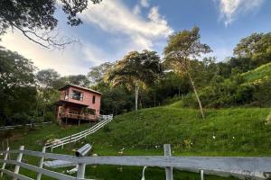 西波山Chalé Canto da Montanha的围栏旁的山丘上的房子